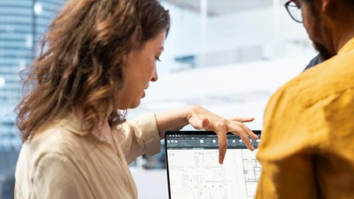 Deux collaborateurs analysent des données de terrain sur un écran